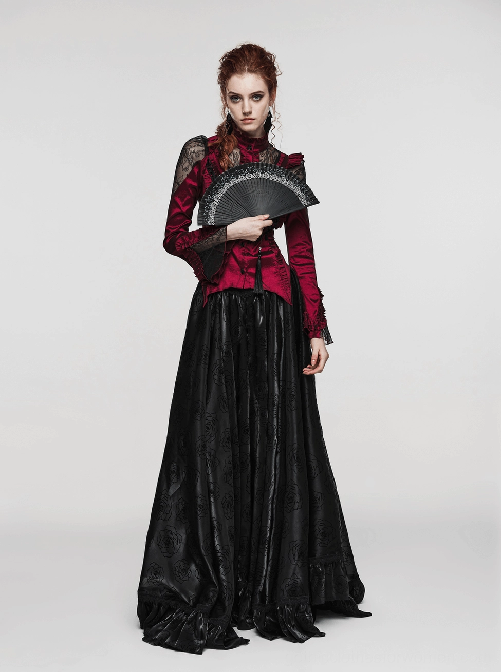 Full-body shot of gothic model in red lace top and black satin skirt with elegant black lace hand fan, complete styling showcase