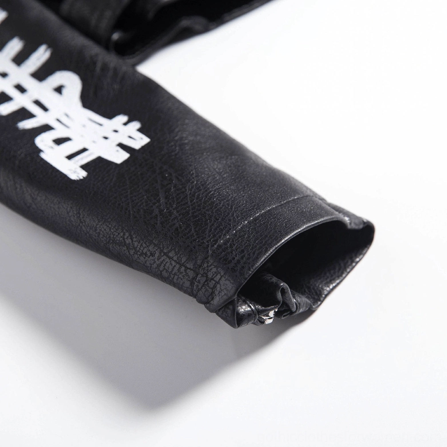 Detailed view of black motorcycle jacket front panel with layered 3D printed text and graphic elements on PU leather