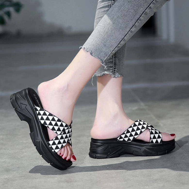Pair of goth-inspired platform slides with geometric triangle pattern and chunky sole, showcasing overall silhouette and profile