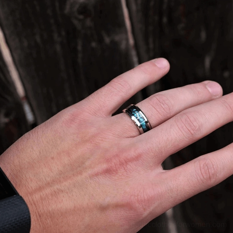 Gothic abalone statement ring worn on index finger close-up showing silver band with iridescent shell inlay detail