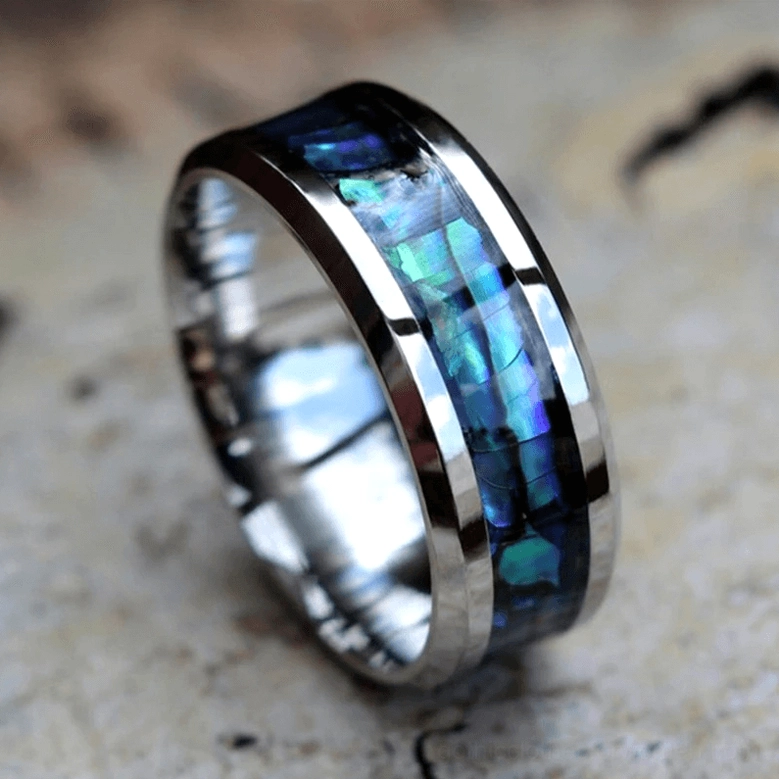 Alternative gothic ring with abalone shell inlay outdoor stone background side perspective