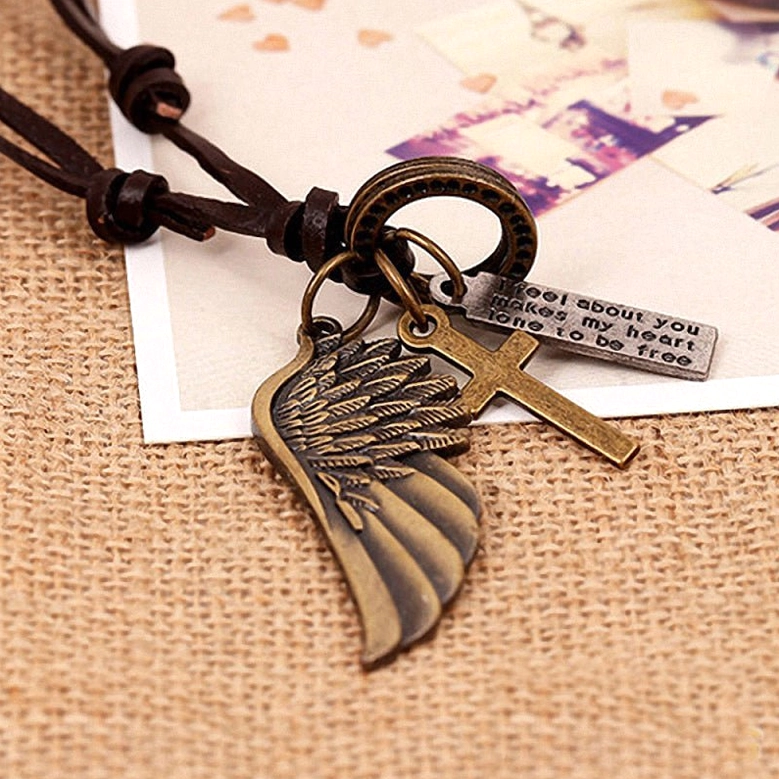 Bronze-toned angel wing charm on brown leather gothic choker necklace, side-angle flat lay detail
