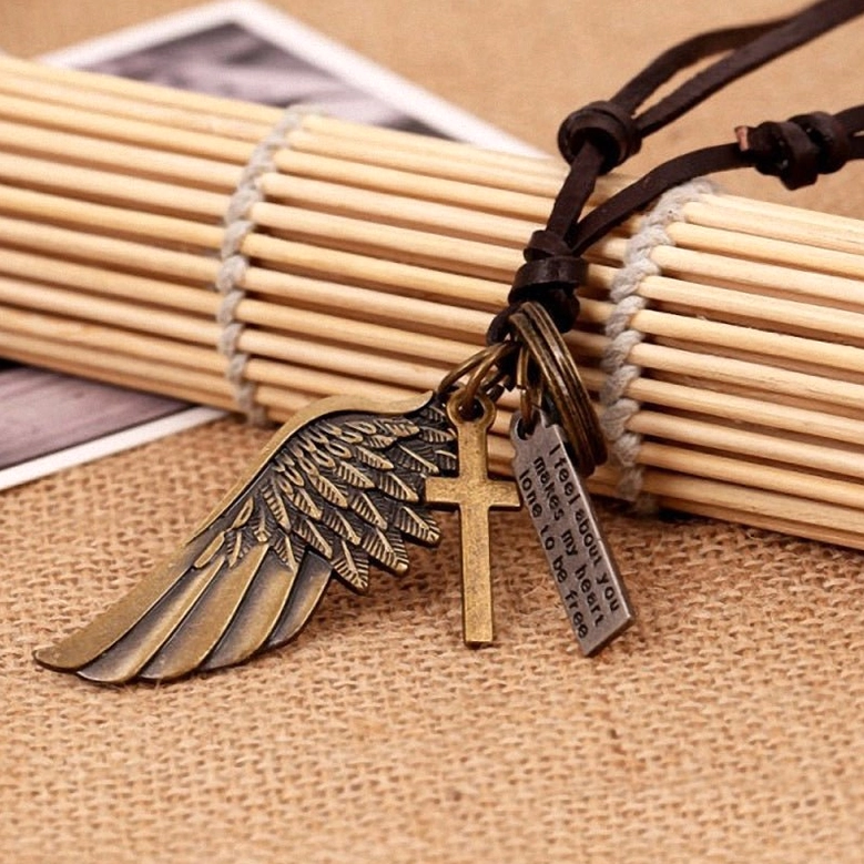 Brown leather gothic angel wing necklace with bronze-toned multi-charm pendants and text tags, flat lay view