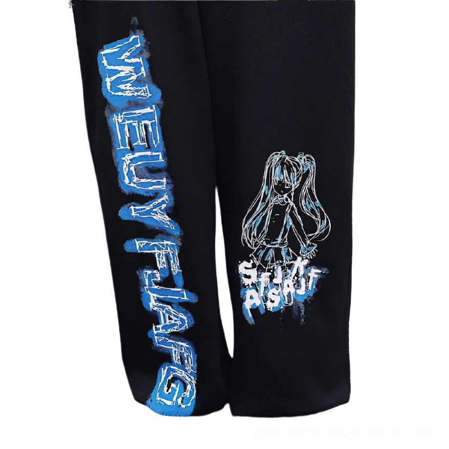 Close-up detail of black gothic anime jogger pants fabric showing blue graffiti text, anime girl print, and black knit texture