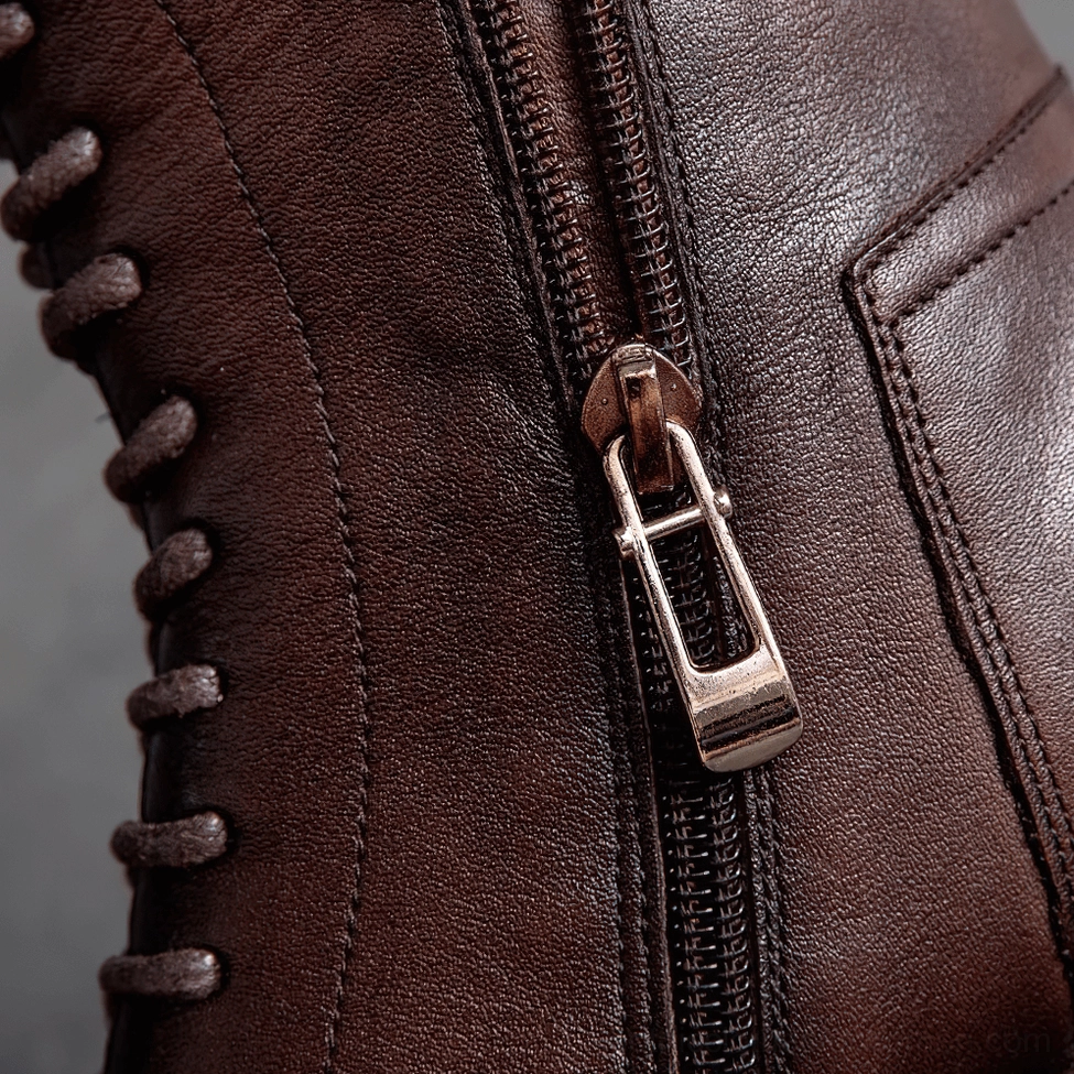 Metal zipper and stitched leather vamp detail of gothic ankle boots in macro close-up