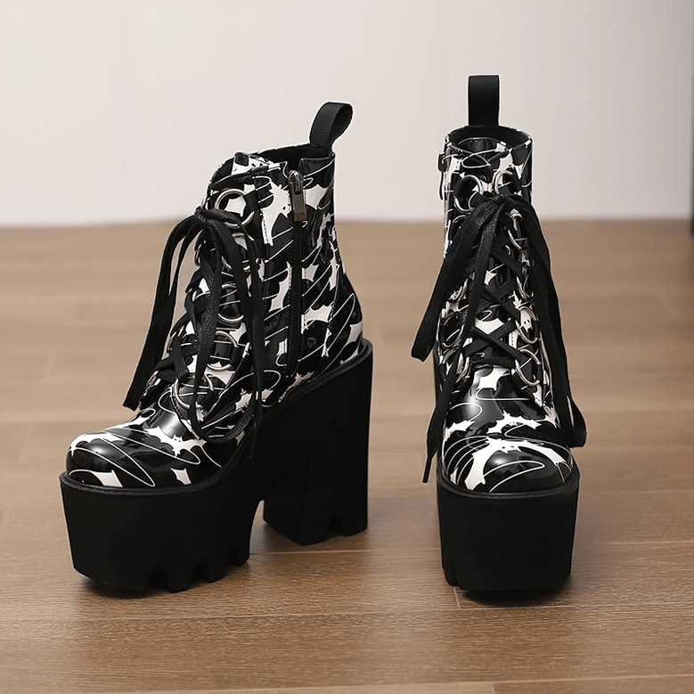 Pair of women's gothic platform ankle boots with bat print pattern standing upright on wooden floor, side profile view showing platform sole height