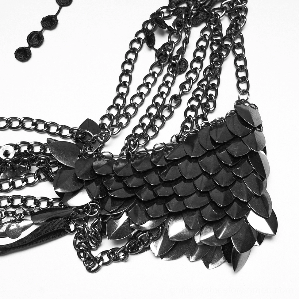Detail view of black lace armor choker metal chains, scale armor, and dangling teardrop pendants in close-up flat lay