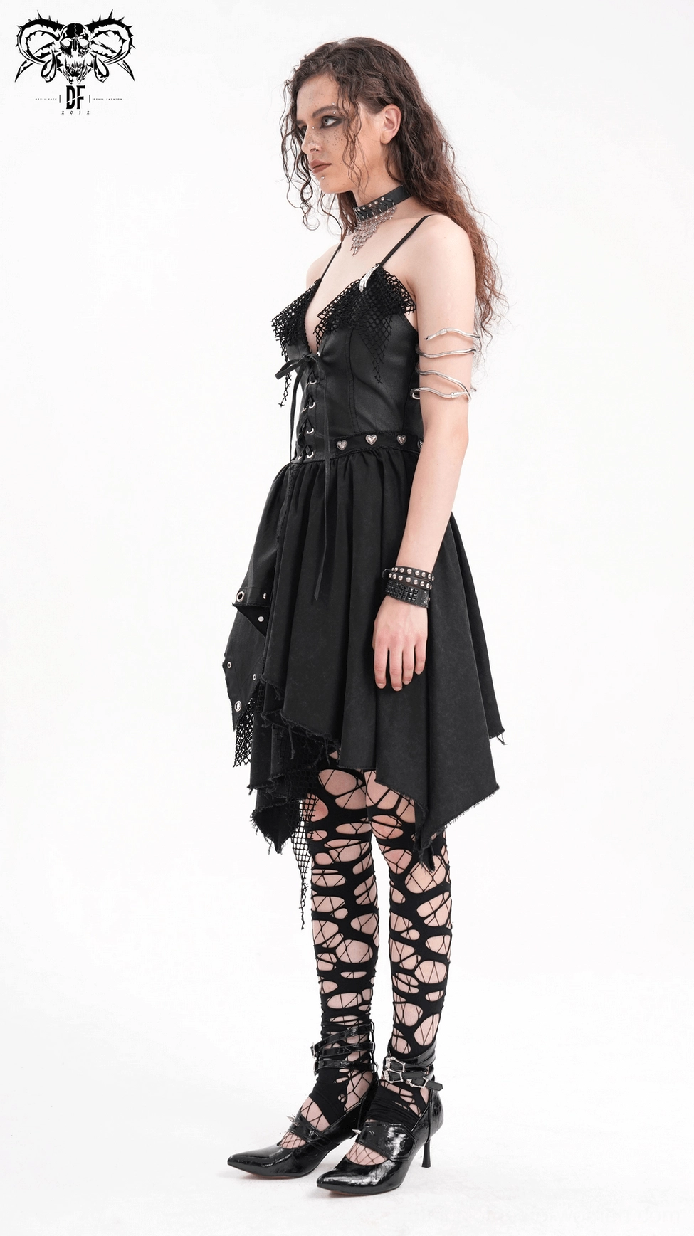 Back detail view of gothic asymmetric dress showing zipper and layered fishnet construction from behind