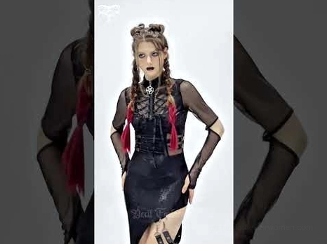 Gothic asymmetrical black dress close-up detail view showing lace-up bodice, mesh sleeves, and high side slit on model