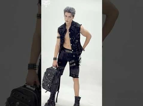 Full body outfit shot of male model wearing gothic skull chain backpack with punk vest and alternative fashion styling