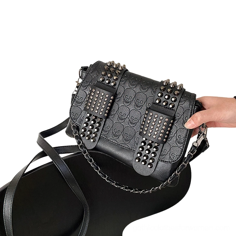Close-up view of rivet decoration on gothic leather crossbody bag - metal accents and embossed skull motif