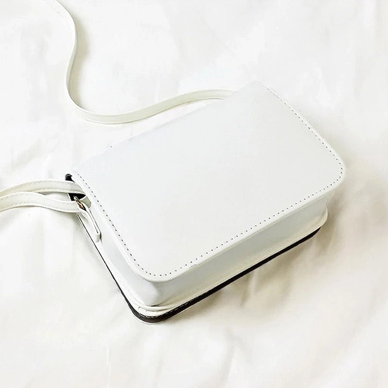 White gothic crossbody bag overhead view showing solid back panel with stitched seams and clean design