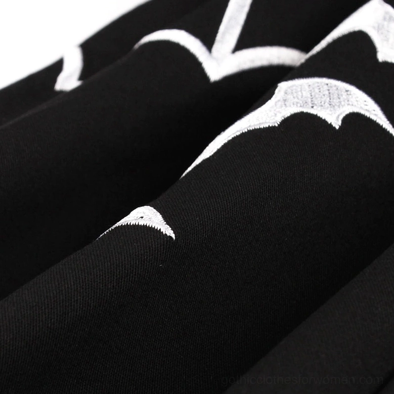 Cap sleeve detail of gothic bat dress showing white scalloped trim on black fabric and short sleeve construction