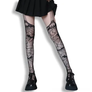 Gothic bat fishnet thigh-high tights with garter cutout details, front view on model wearing platform loafers