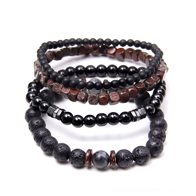 Dark aesthetic beaded bracelet collection overhead shot featuring lava stone black stone and natural wood beads with minimalist metal spacer accents