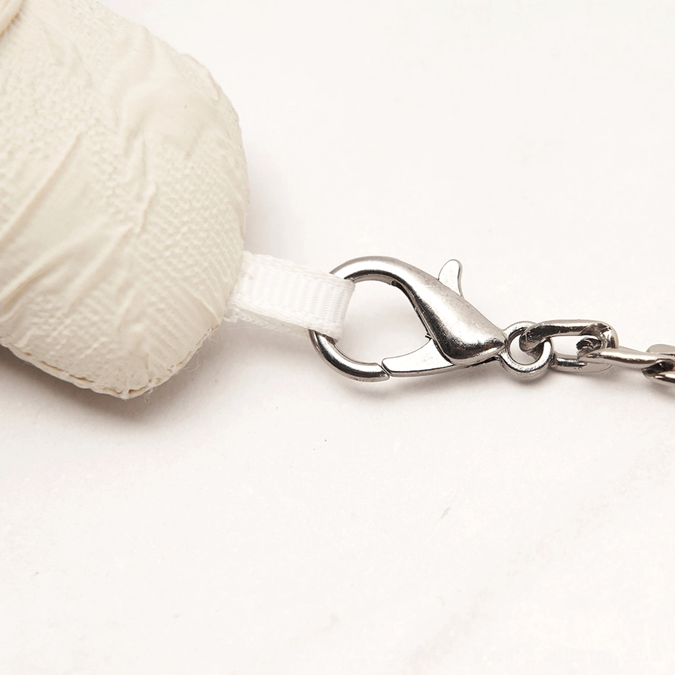 Macro detail of silver lobster clasp and chain connector on gothic bear pendant