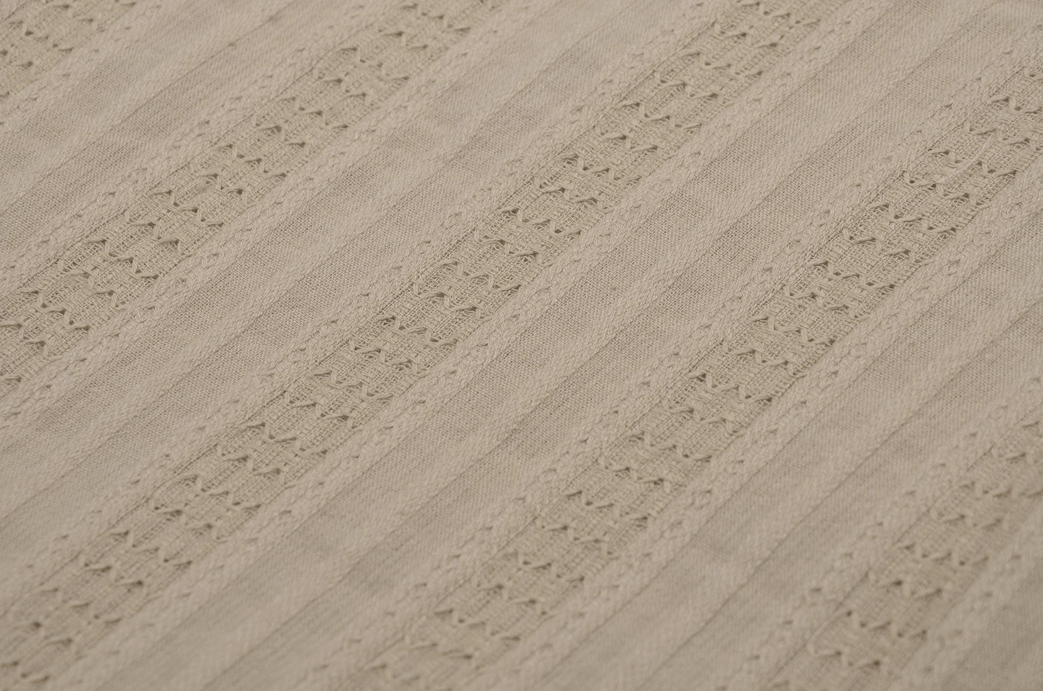Close-up textile detail of gothic beige skirt showing striped weave pattern, eyelet cutout details, and cotton fabric quality