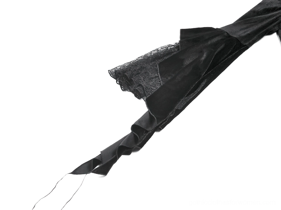Close-up detail of gothic bell sleeve showing velvet fabric with lace trim and hanging tassel cuff accent