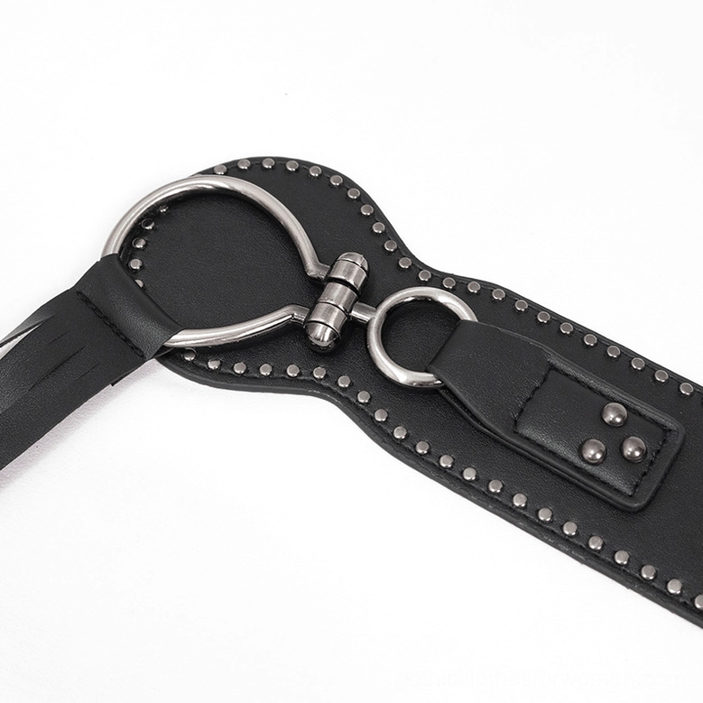Close-up flat lay of gothic belt hardware showing metal O-rings and studded leather trim detail shot