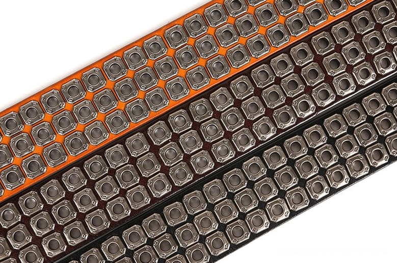Close-up detail of square metal grommet pattern on studded gothic leather belt strap, showing craftsmanship