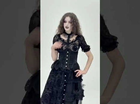 Gothic black corset dress set styled on model featuring high neck lace top and structured underbust corset with front buttoned details