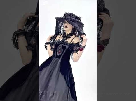 Gothic vintage formal black gown styled with wide-brimmed hat and dark aesthetic - dramatic gothic fashion photography