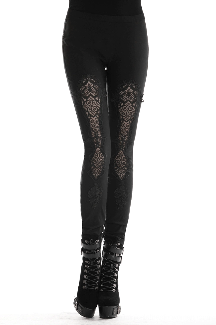 Black gothic lace-up leggings with thigh lace inserts worn by model in studio, front low-angle view showing lace panel details and ankle lace-up design