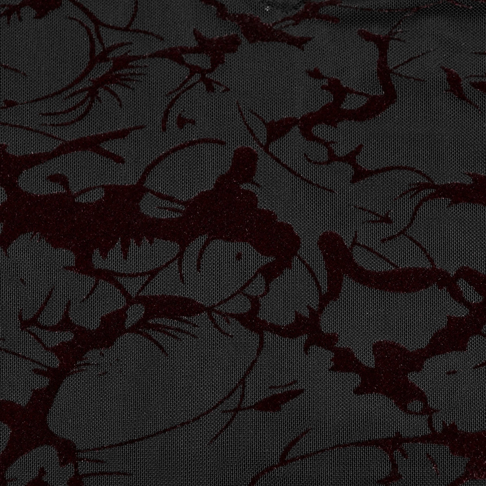 Close-up fabric detail of gothic maxi dress showing dark red vine and floral print on black sheer mesh base
