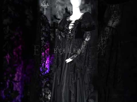 Black gothic lace dress side view captured in moody purple ambient lighting showing bell sleeves and floor-length layered skirt
