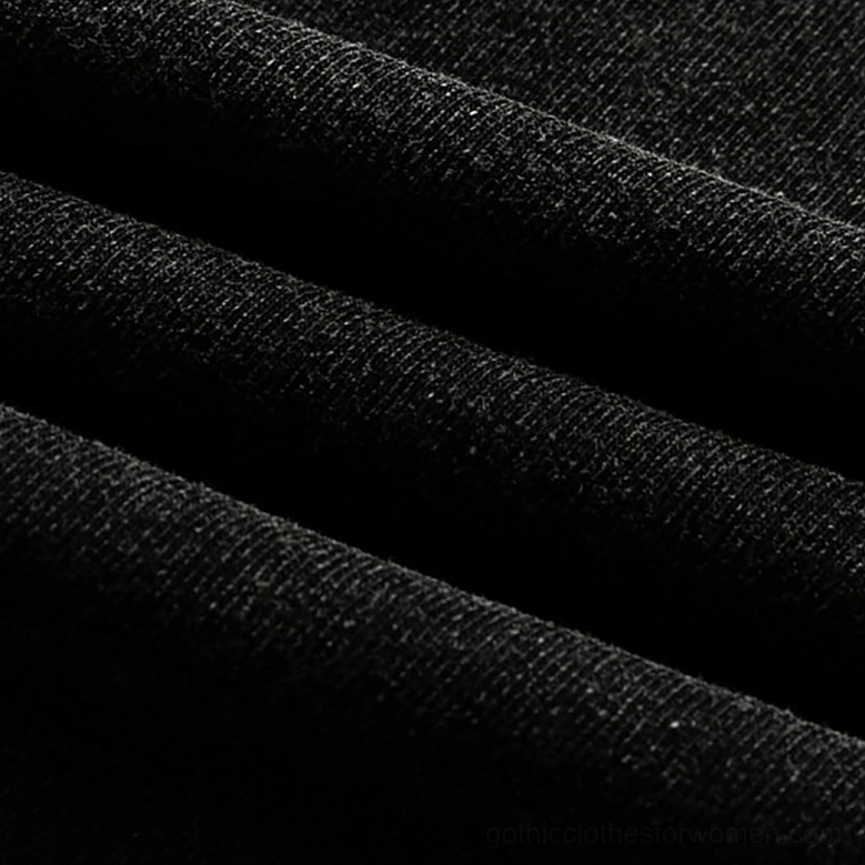Fabric drape close-up of washed black cotton knit showing natural folds and soft brushed texture of oversized gothic graphic tee