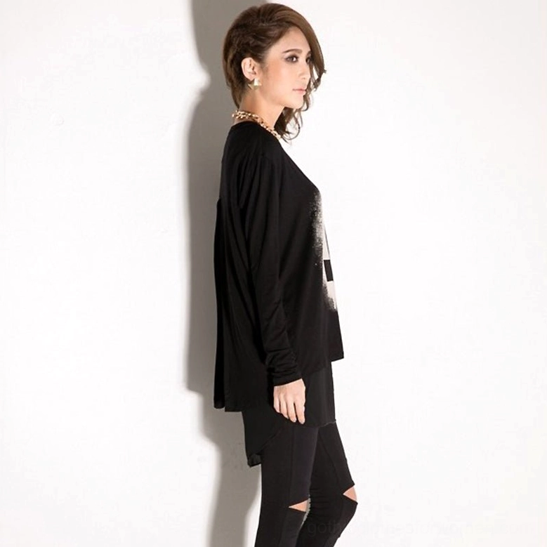Black gothic loose long sleeve tunic top on model with ripped skinny jeans, side three-quarter view, streetwear goth styling