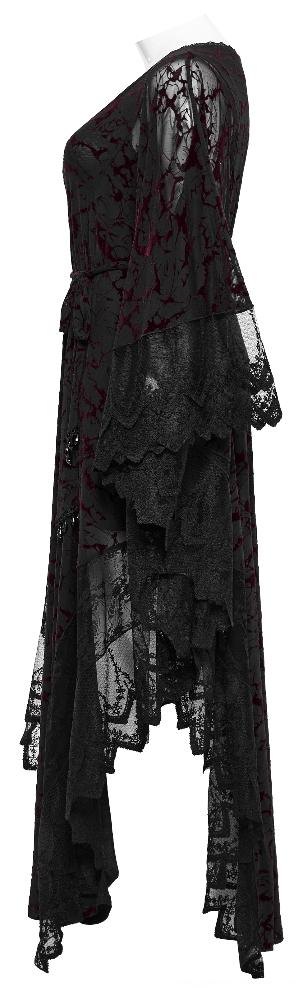 Gothic black maxi dress side view showing asymmetrical floor-length hem and fitted waistline with pendant accents