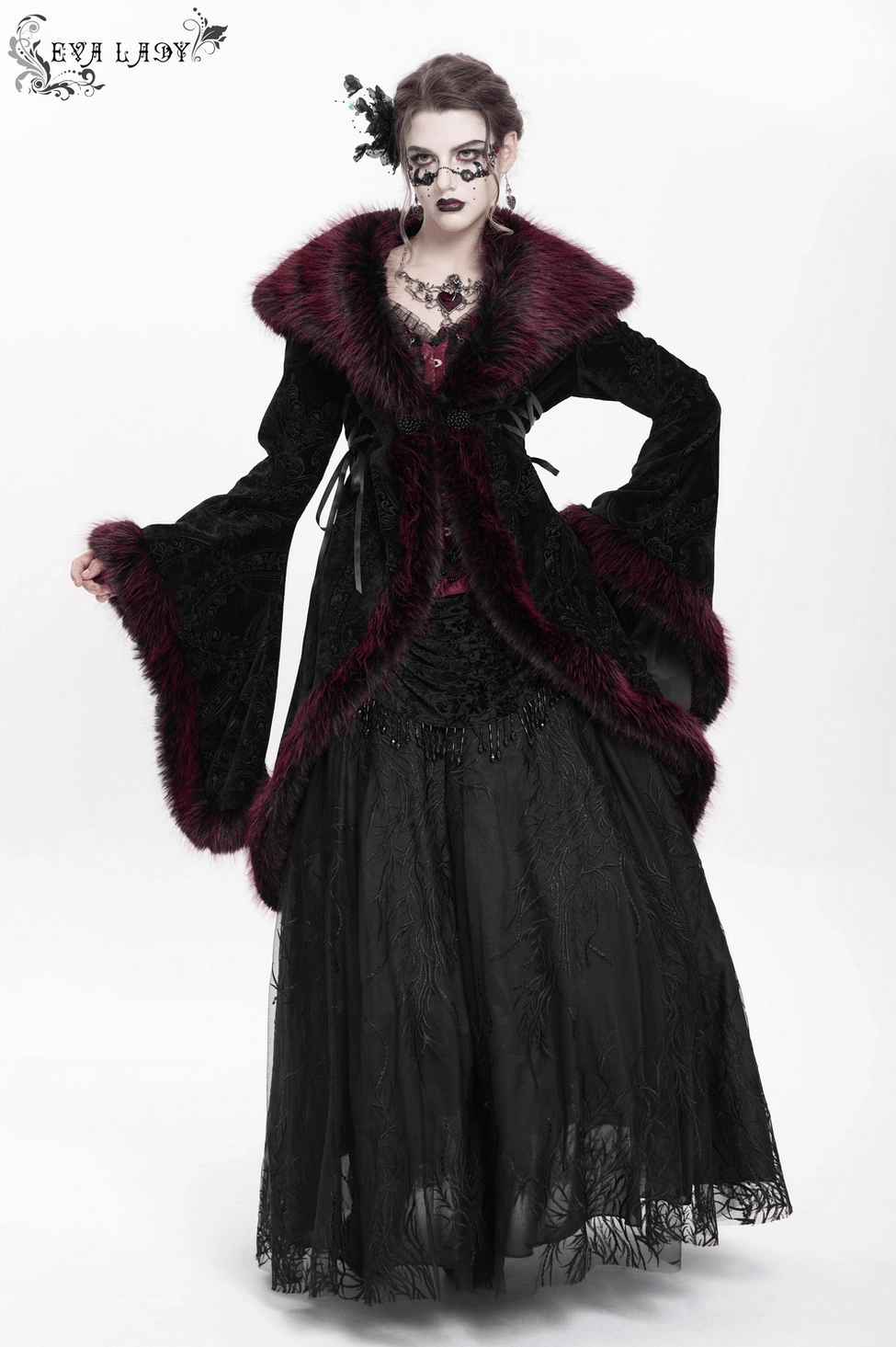 Full garment view of black velvet gothic coat displayed flat showing complete silhouette, all trim details, and burgundy faux fur accents