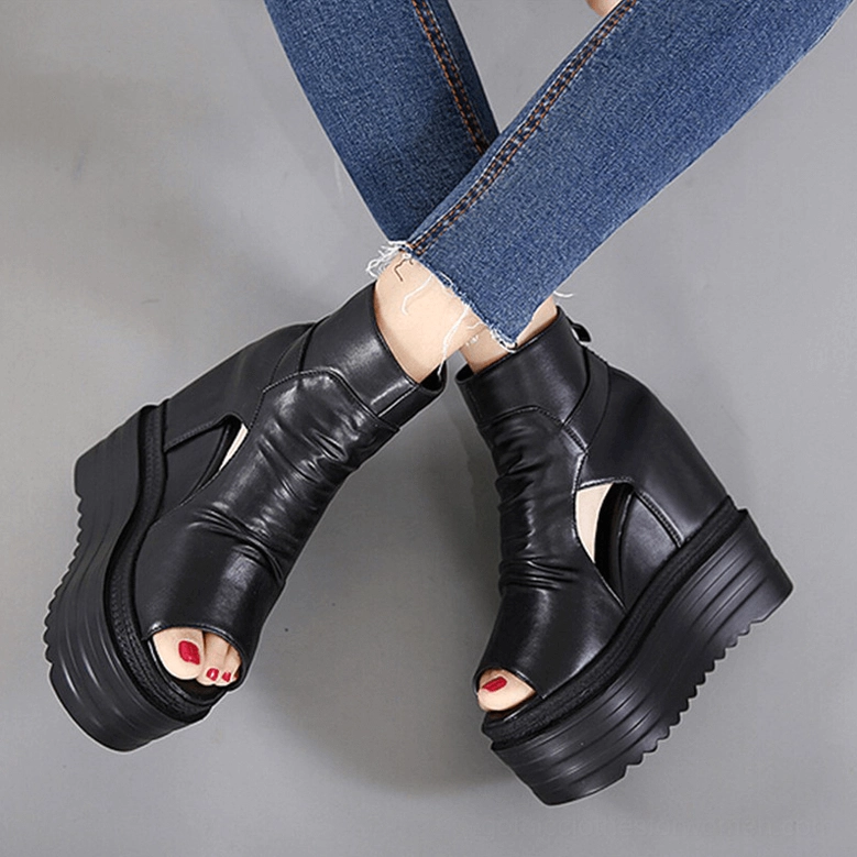 Gothic black wedge platform boots worn with blue jeans overhead view showing peep toe design