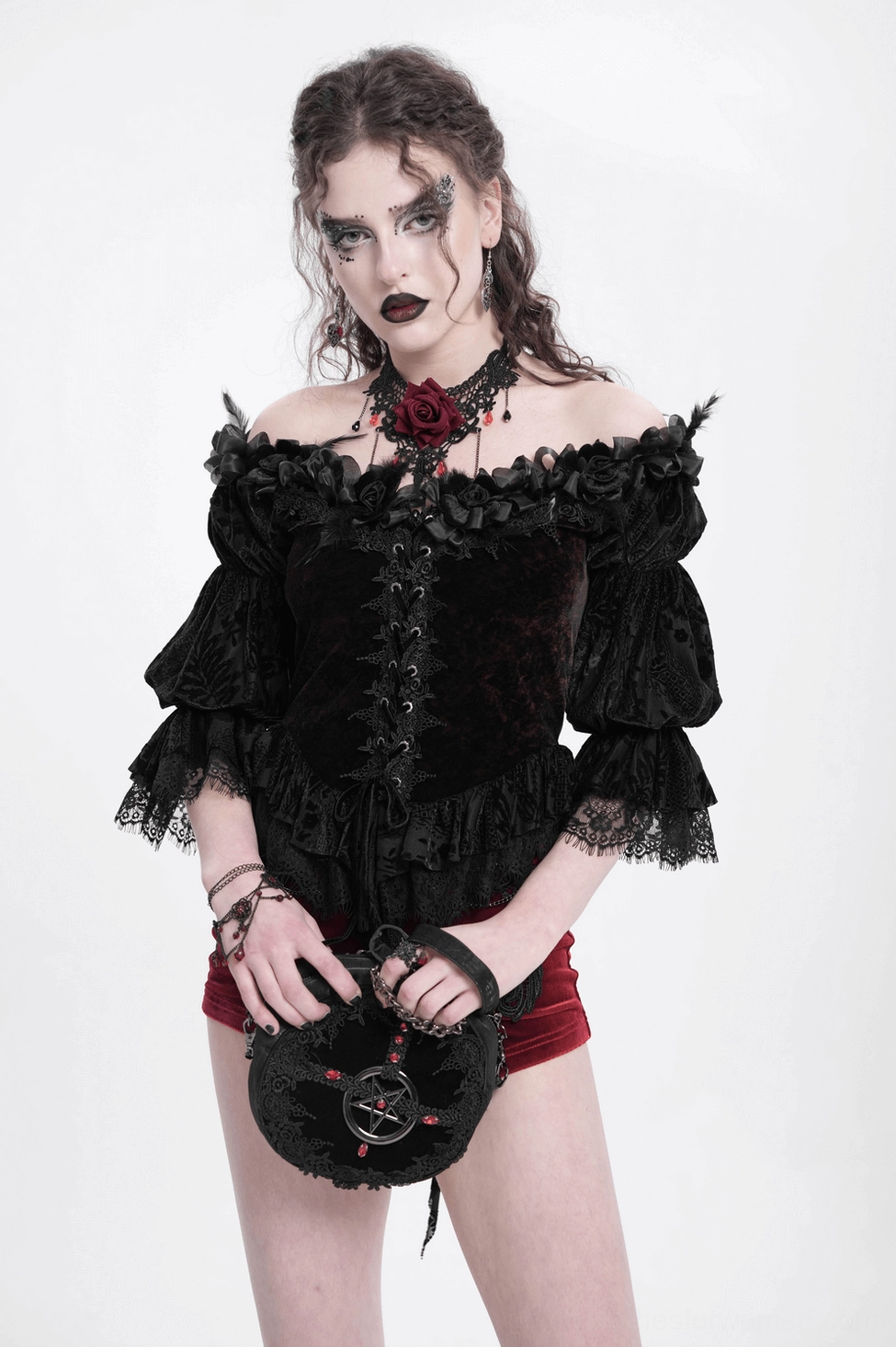 Detail view of gothic blouse asymmetrical hem and embroidered lace pattern on off-shoulder velvet garment