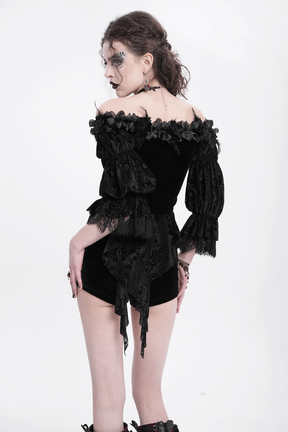 Gothic blouse detail photograph highlighting asymmetrical hem, lace construction, and layered ruffled design elements