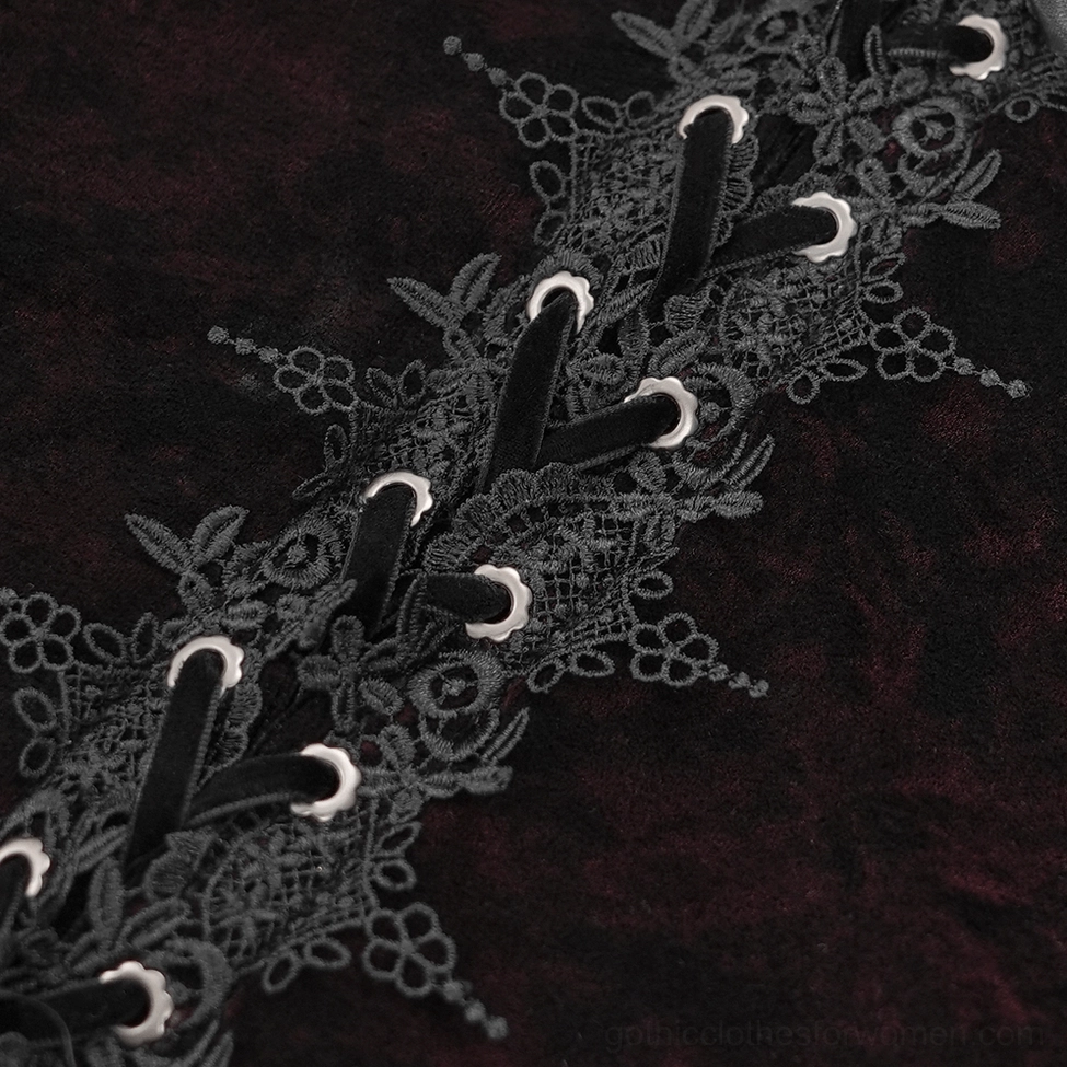 Close-up detail of gothic blouse showing wine red velvet texture and black lace-up corset closure mechanism