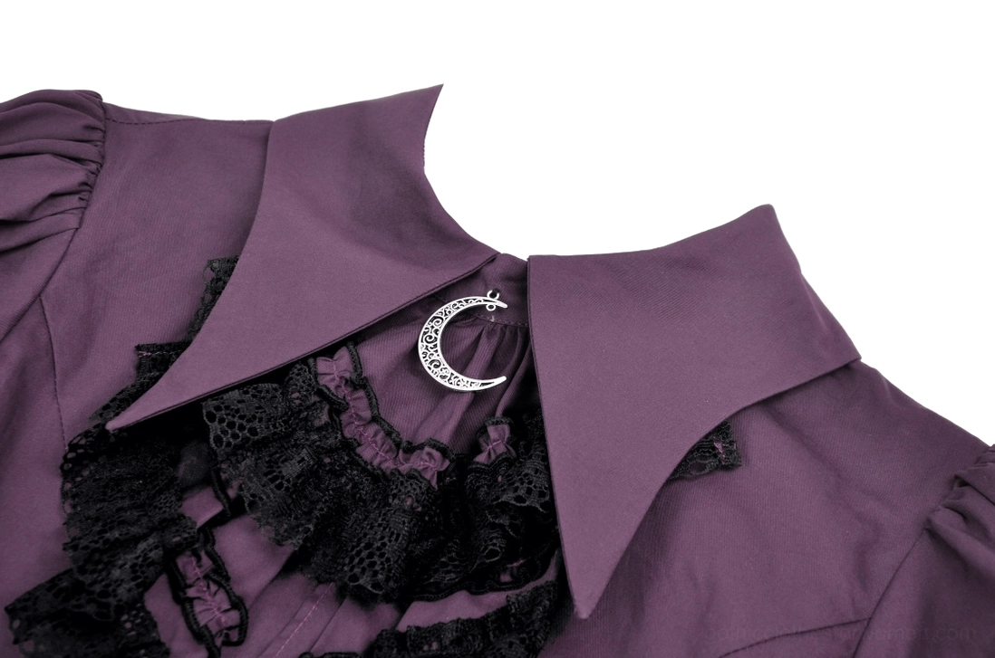 Close-up detail of blouse collar showing crescent moon pendant brooch and layered black lace ruffles