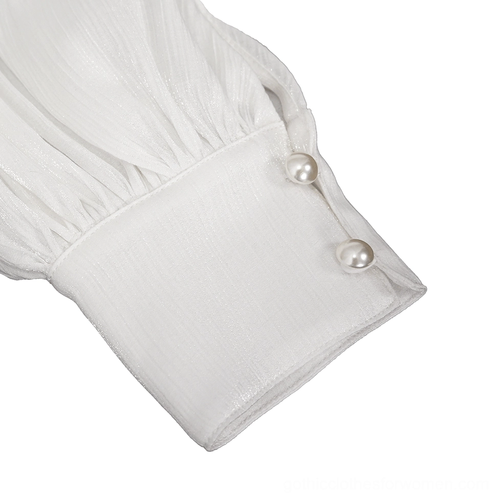 Close-up detail of white gothic blouse cuff featuring pearl buttons and gathered sheer fabric texture with delicate edge finishing
