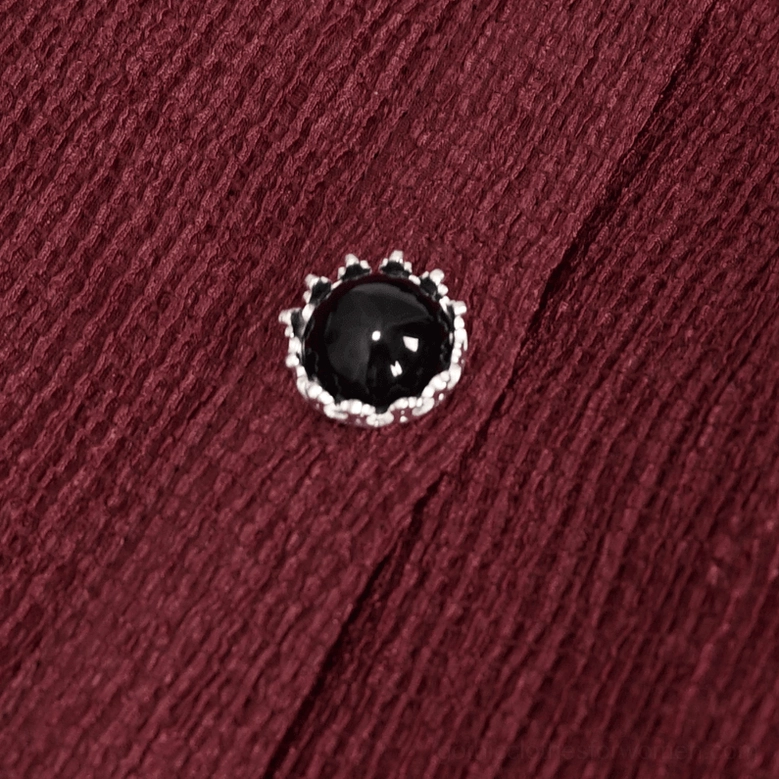 Close-up of wine red gothic blouse gem-inlaid decorative button and textured fabric