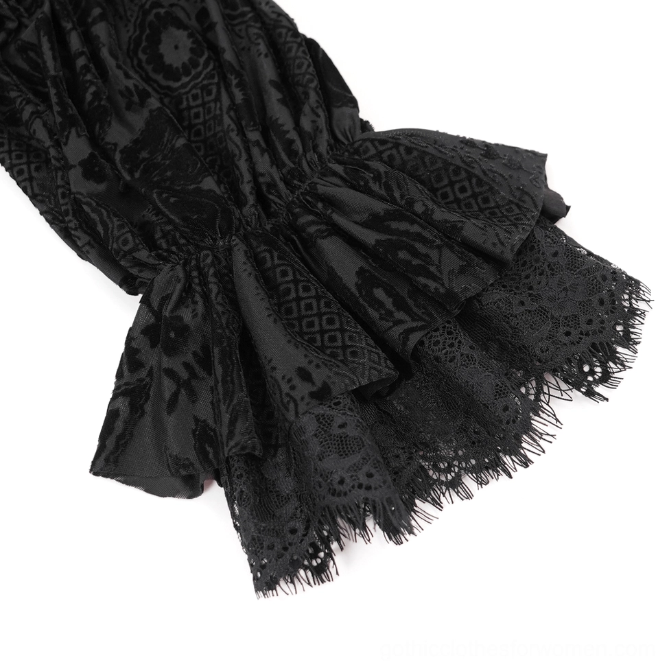 Flat lay detail shot of gothic off-shoulder velvet blouse highlighting embroidered lace and velvet fabric quality