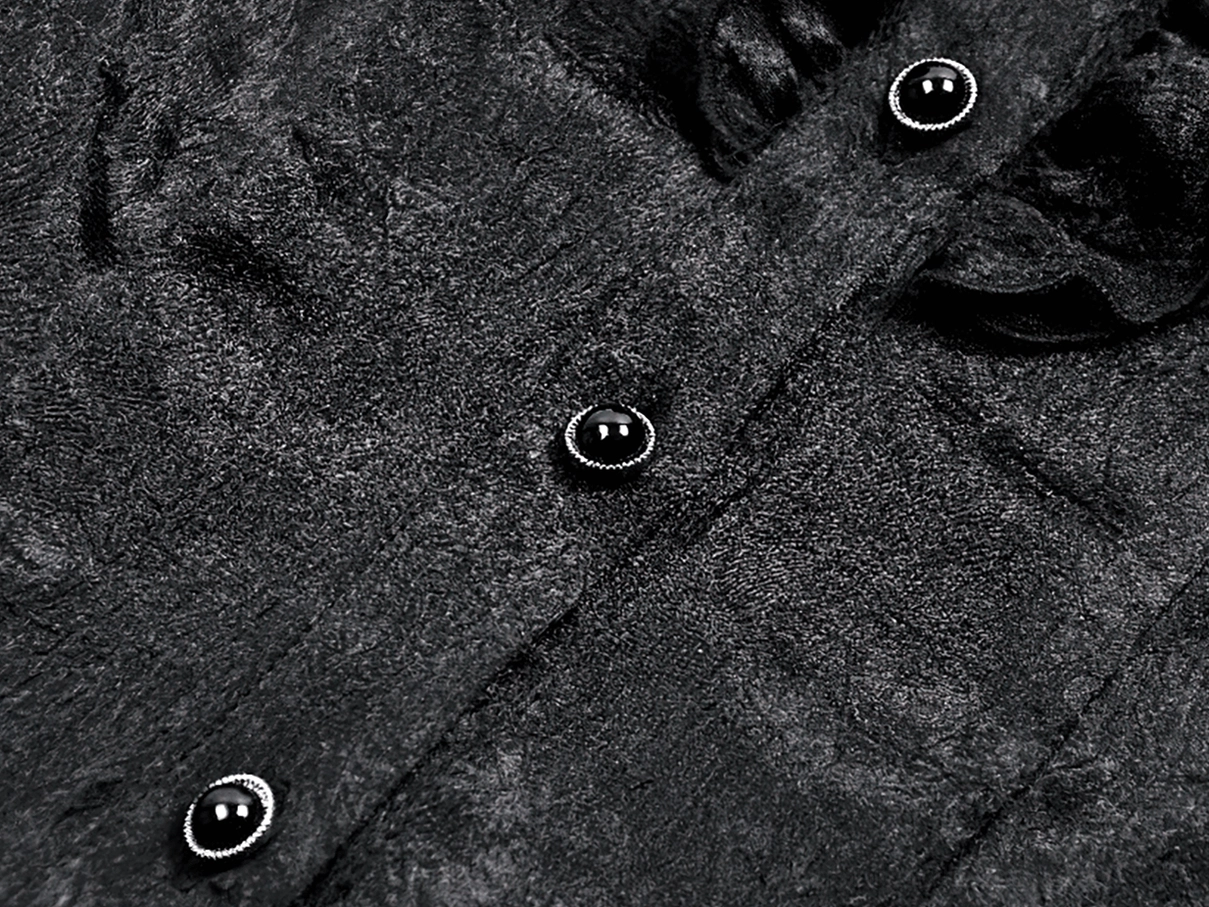 Close-up of black satin fabric texture and silver-trimmed decorative buttons on gothic victorian blouse