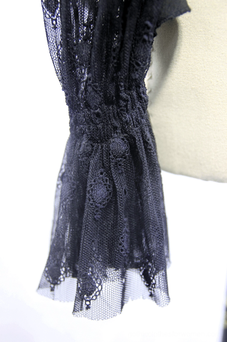 Close-up detail of gothic blouse waist section showing crochet lace fabric with gathered waist and scalloped edge trim