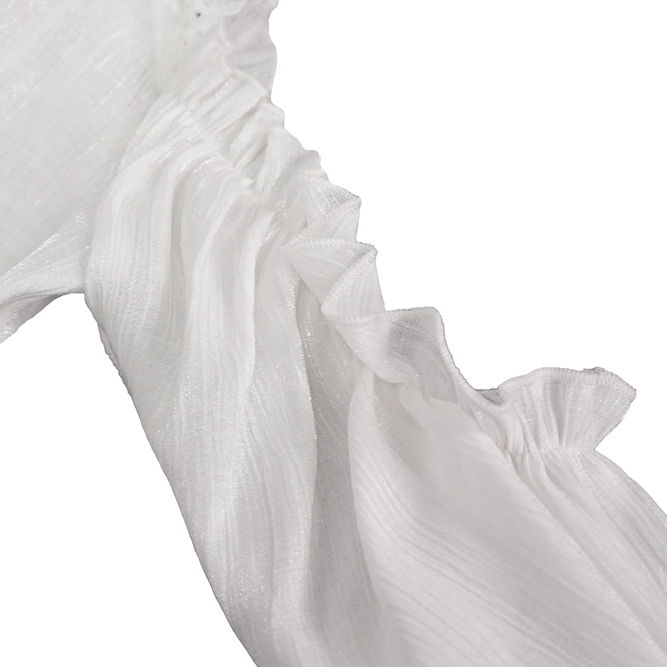 Macro close-up of ivory gothic blouse shoulder ruffle showing wrinkled sheer fabric texture and delicate ruffled edge construction
