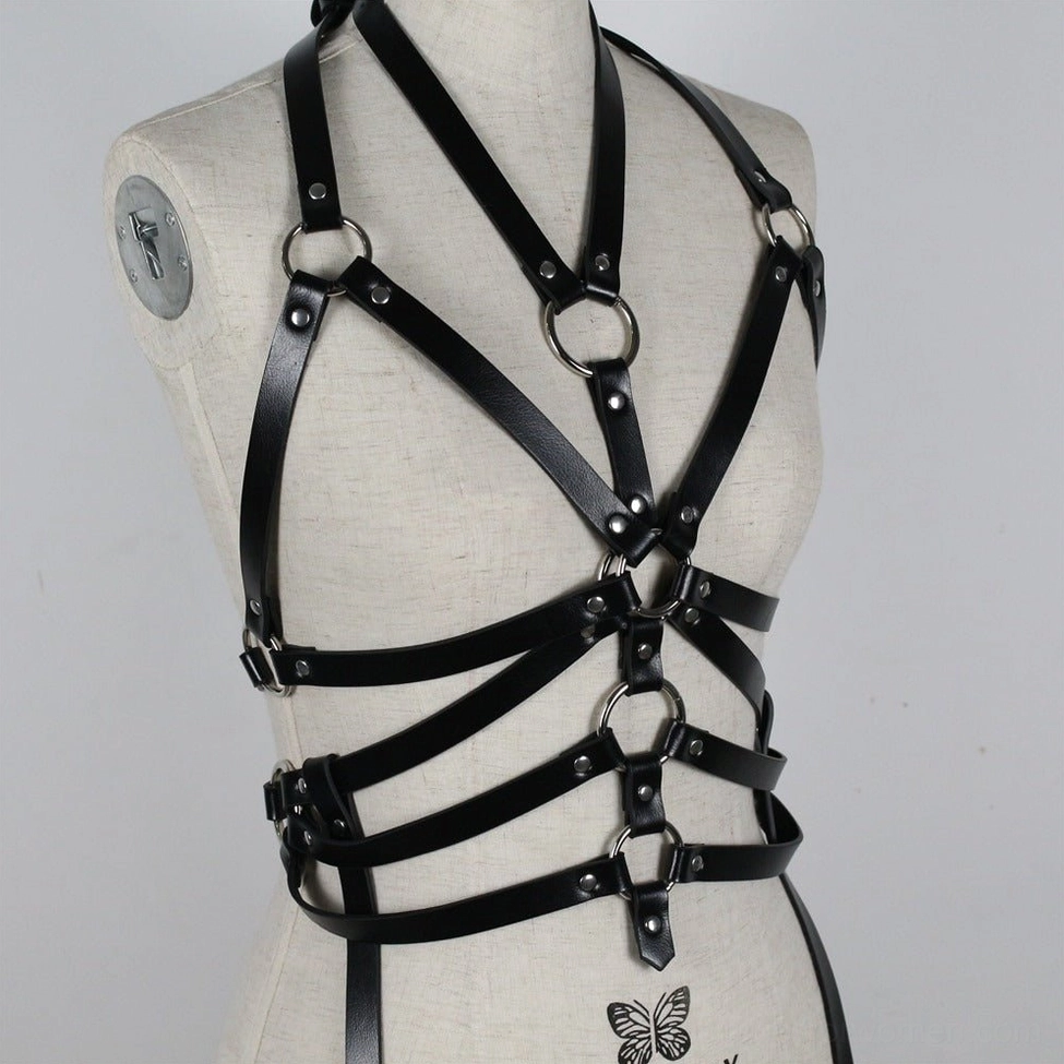 Gothic bondage harness belt with metal ring details and adjustable strap system positioned for maximum visual impact