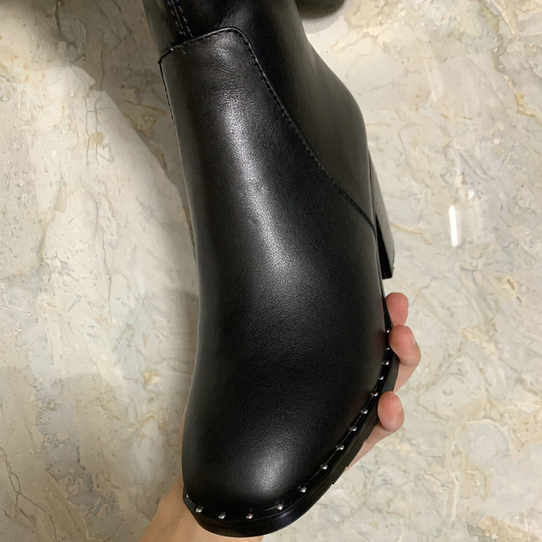 Black leather over-the-knee boots featuring side panels and elastic construction for comfortable custom fit
