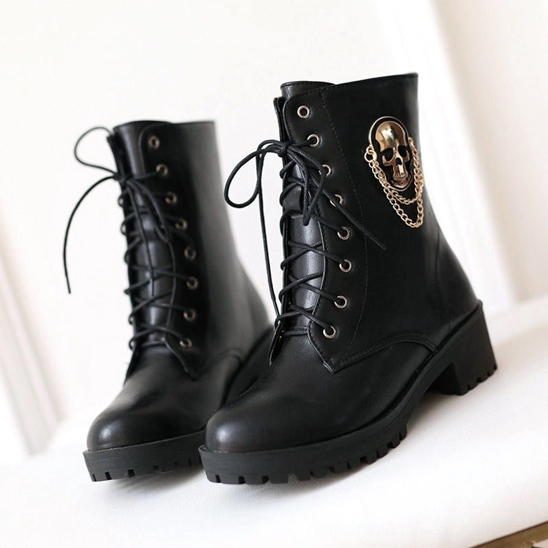 Front eye-level view of black gothic combat boots with metal skull chain accent and lace-up closure, white background