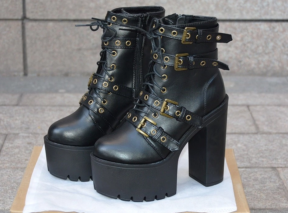 Dynamic side angle of black gothic boots showing lace-up fastening system, metal eyelets, and waterproof platform sole design
