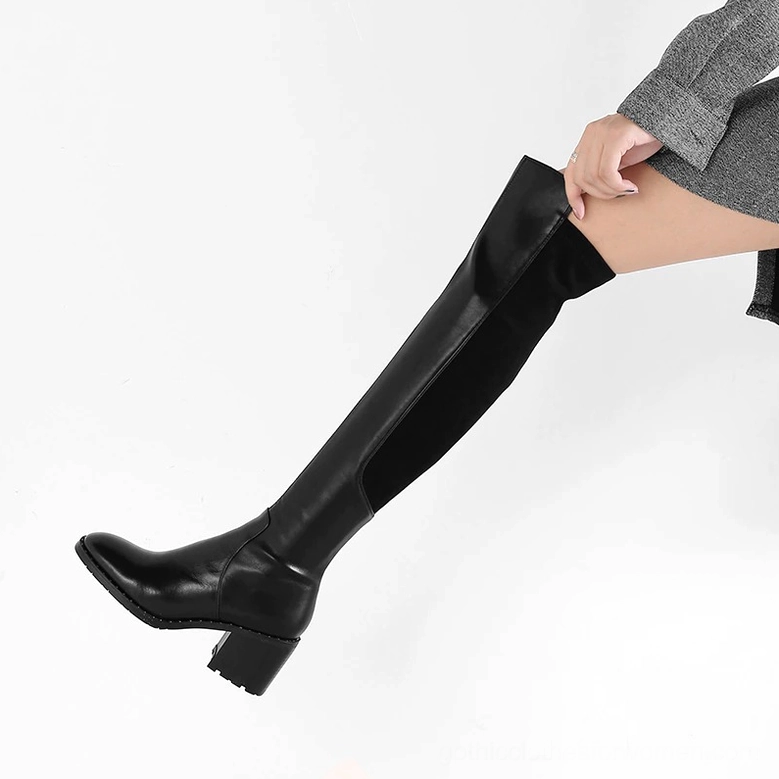 Woman wearing black leather over-the-knee gothic boots with functional side zipper and stretch side panels