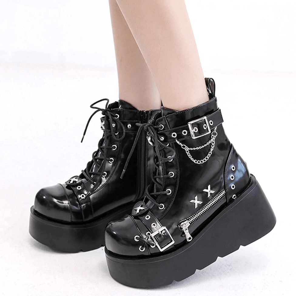 Styled gothic platform ankle boots showing patent leather upper and side zipper closure on model